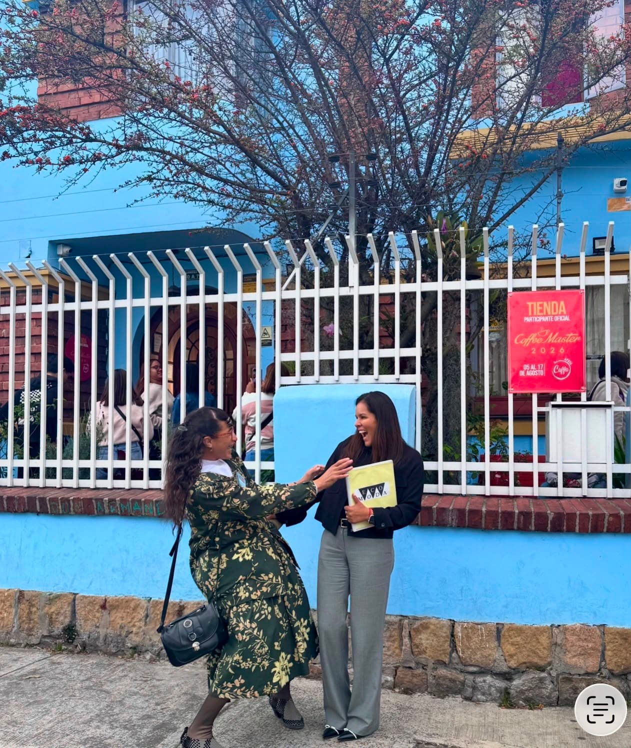 Viajeras felices frente a una casa azul tradicional de Bogotá